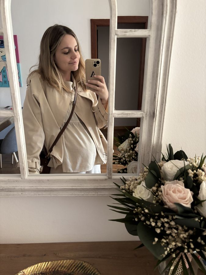Anabela embarazada frente al espejo de casa, sonriendo
